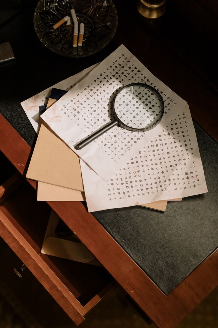 gallery-5 A vintage office scene with cryptic documents and a magnifying glass, evoking mystery and detective work.
