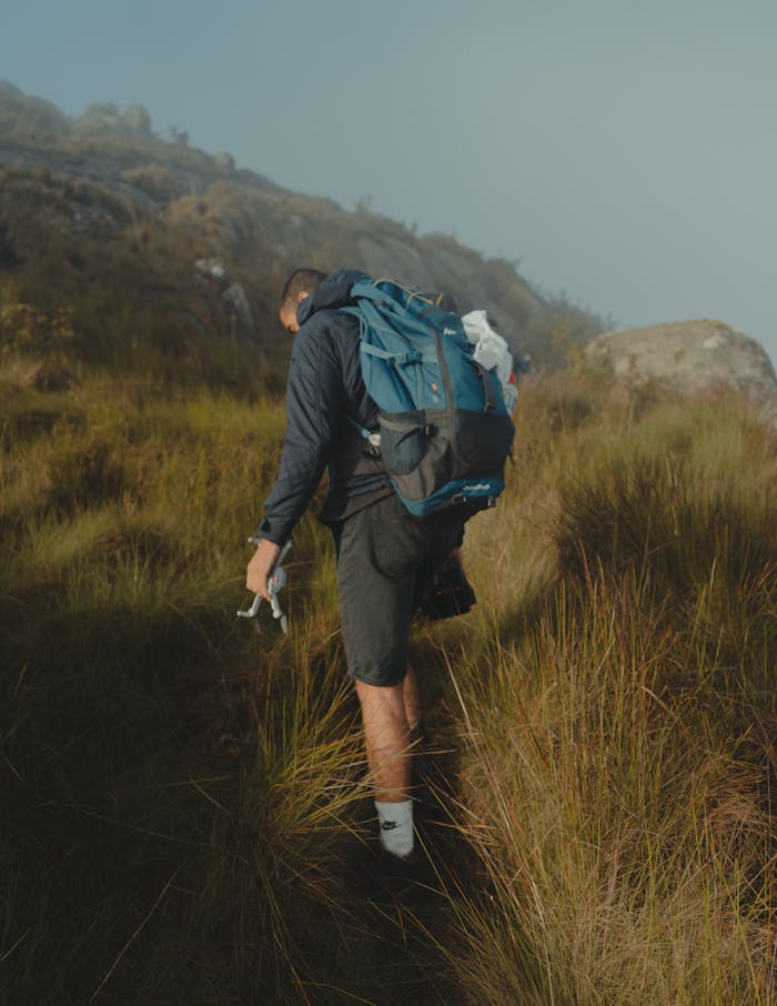 gallery-4 A solo adventurer hiking through misty hills with a backpack, capturing the essence of outdoor travel.